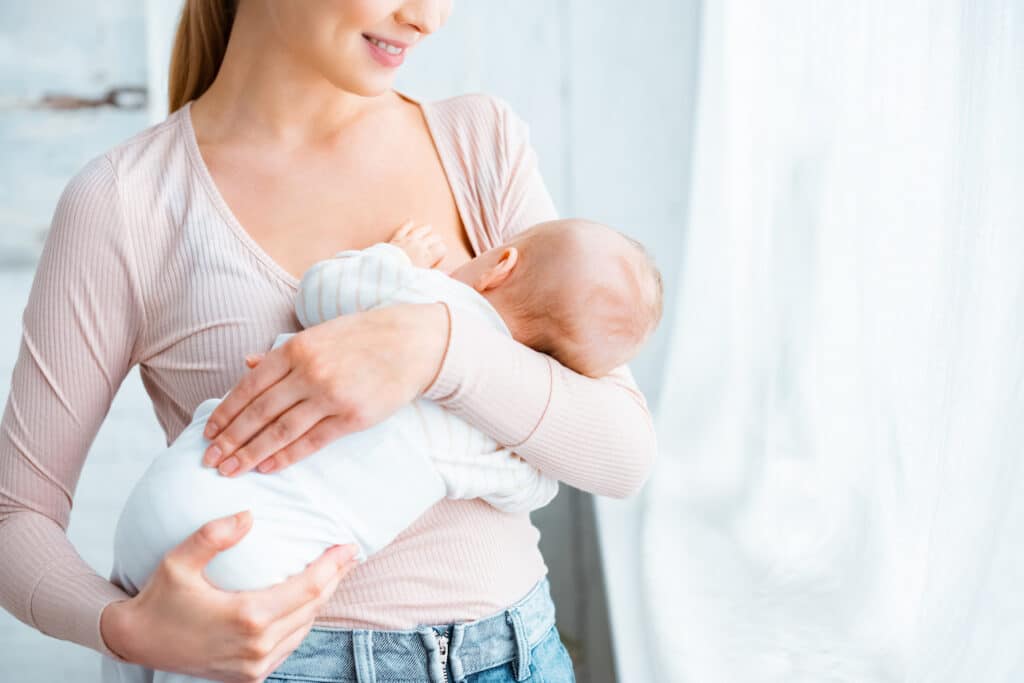 mom breastfeeding using correct breast positioning